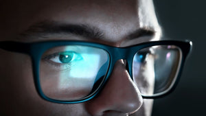 man with glasses working at computer
