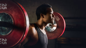 man with barbell doing back squats