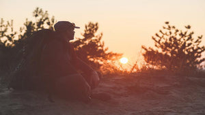 man with backpack sitting outside