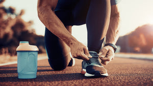 man tying his shoe before a workout