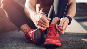 man tying shoelaces on running shoes