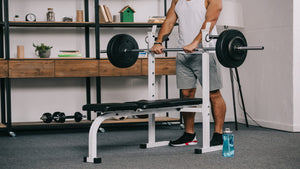 man setting up bench and weights in home gym