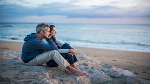 middle aged man and woman sitting on beach