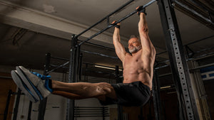man doing hanging leg lift core exercise