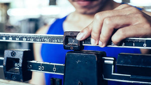 man weighing himself on a scale